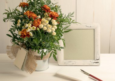 Retro fotoğraf çerçevelemek ve yaprak kağıt ve tagetes bouqu ile eski kalem