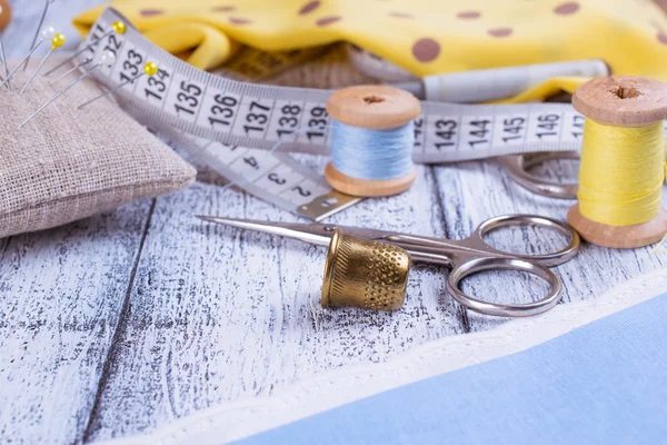 Tools for sewing and fabric on wooden boards — Stock Photo, Image