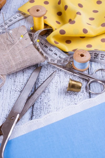 Hulpmiddelen voor het naaien en stof op houten planken — Stockfoto