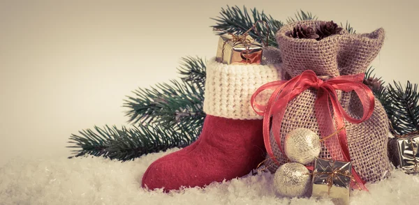 Julenissens støvel og gavepose på snø . – stockfoto