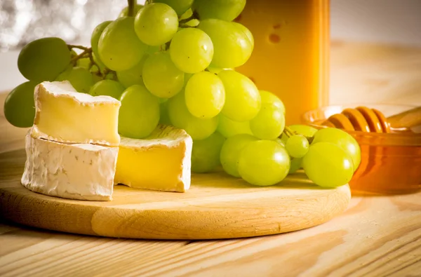 Still life of cheese, honey and grapes — Stock Photo, Image