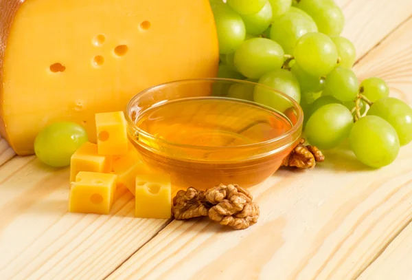 Bodegón de queso, miel, nueces y uvas — Foto de Stock