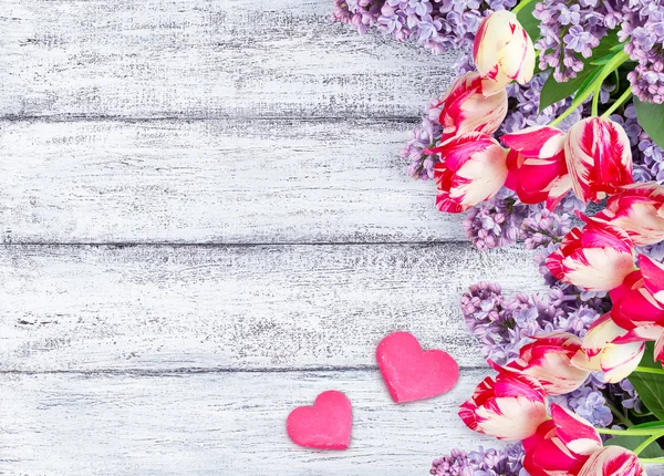 Lilac flowers with tulips and two hearts — Stock Photo, Image