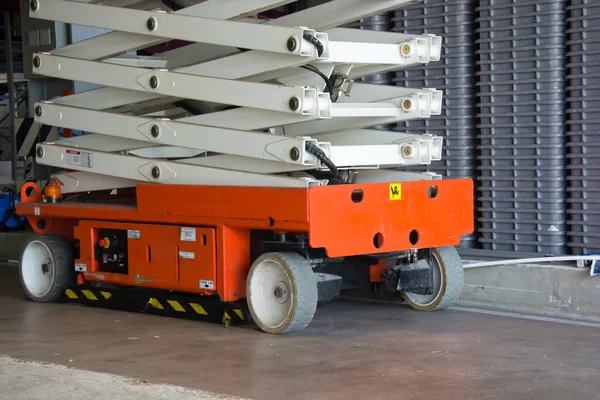 Warehouse hall with hydraulic scissors lift — Stock Photo, Image