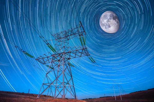 Electricidad postes de energía en el cielo nocturno y startails luna backgrou — Foto de Stock