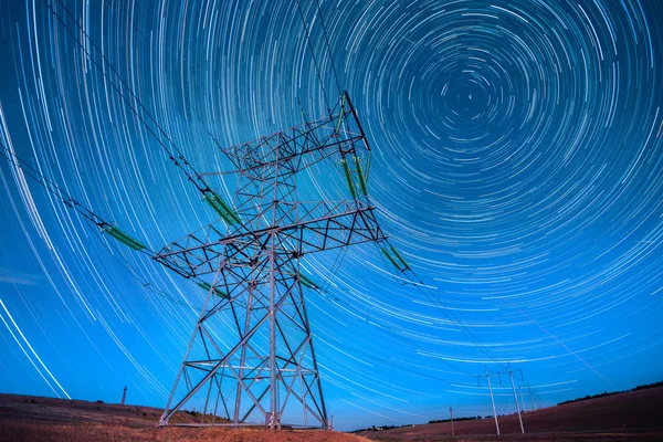 Electricidad postes de energía en el cielo nocturno y startails luna backgrou Imagen de archivo