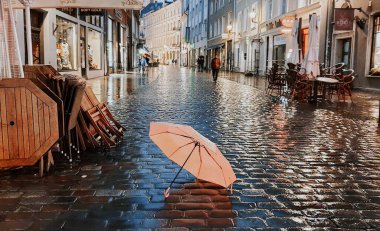 Sarı yapraklar dökülüyor, Tallinn 'deki eski kasabada sonbahar akşamı ıslak kaldırımda pembe şemsiye, sarı yapraklar düşüyor şehir ışığı, yağmurlu mevsim hava tahmini, yağmurlu şehir tahmini