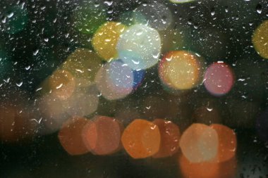 Pencereye düşen yağmurlu su damlaları bulanık mavi ışık yansıma yağmuru desenli arka plan hava durumu 