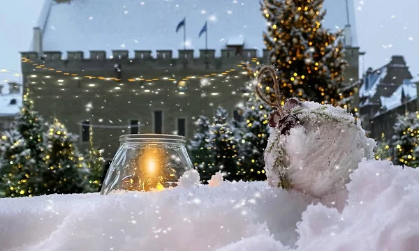 Snowy City street,winter in Tallinn old town hall square yellow candle and white christmas ball in a snowdrift ,christmas tree blurred  light ,snowy weather in Estonia