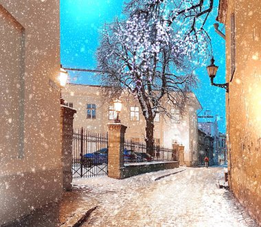 Tallinn 'in eski panorama kasabasında kar yağışlı ortaçağ şehir çatı evi ve Estonya' daki belediye binasında kar taneleri düşüyor. 