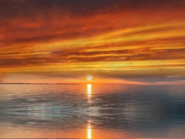   Deniz batımında güzel bir gün batımı pembe altın sarısı bulutlar üzerinde mavi mavi gökyüzü yarı akşam, su dalgası doğa manzarası yansıması
