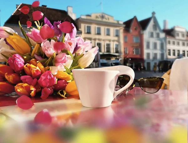 cup of coffee at table at street cafe and flowers tulip spring season in Tallinn Estonia