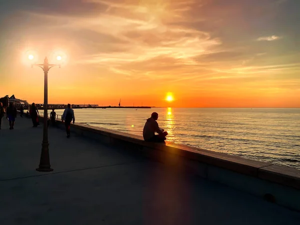 Sylwetka Mężczyzny Siedzącego Parapecie Zachód Słońca Promenadzie Molo Ludzie Relaks — Zdjęcie stockowe