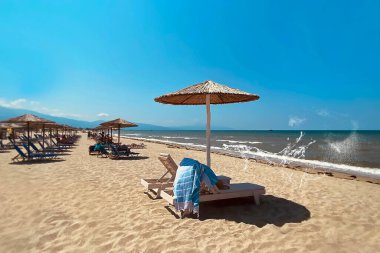  saman şemsiyeler ve ahşap şezlonglar plaj mavi gökyüzünde ahşap masa, Yunanistan 'da beyaz kum yazı egzotik tropikal tatil beldesi Akdeniz manzarası pn ufku Olimpik dağ panorama tatil tatili