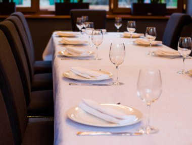 Çatal bıçaklı bir restoranda masa örtüsü şarap ve su için beyaz masa örtüsü.