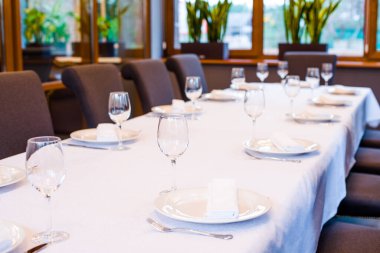 Çatal bıçaklı bir restoranda masa örtüsü şarap ve su için beyaz masa örtüsü.