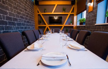 Çatal bıçaklı bir restoranda masa örtüsü şarap ve su için beyaz masa örtüsü.