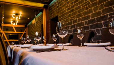 Çatal bıçaklı bir restoranda masa örtüsü şarap ve su için beyaz masa örtüsü.