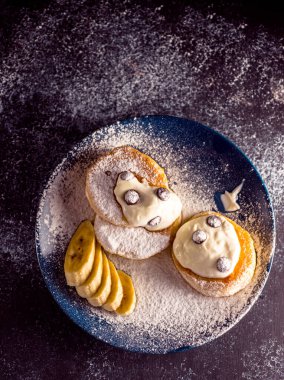 Muz, çikolata ve böğürtlen ve ekşi krema serpiştirilmiş küçük, kalın bir krep.