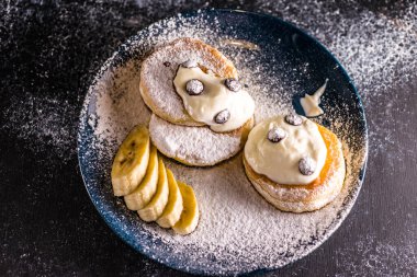 Muz, çikolata ve böğürtlen ve ekşi krema serpiştirilmiş küçük, kalın bir krep.