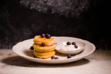 Krep küçük peynirli kekler lezzetli ekşi krema ve çikolatalı güzel bir tabakta böğürtlenlerle
