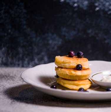 Krep küçük peynirli kekler lezzetli ekşi krema ve çikolatalı güzel bir tabakta böğürtlenlerle