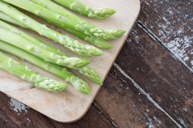 Koyu ahşap masa üzerinde kuşkonmaz
