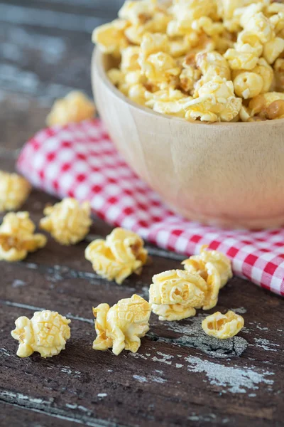 Popcorn in brown bowl on dark wooden table. — Stock Photo, Image