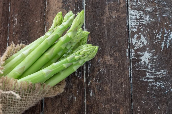 Spargel auf dunklem Holztisch — Stockfoto