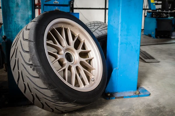 Rueda deportiva y neumático entre horas de mantenimiento en garaje —  Fotos de Stock