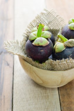 Mangosteen ahşap masa üzerinde ahşap kase
