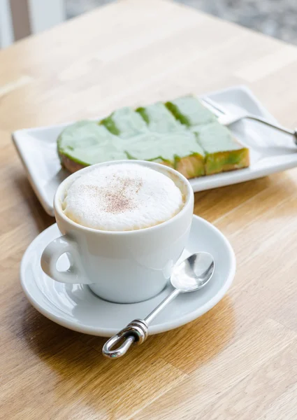 Warme koffie en brood op houten tafel — Stockfoto