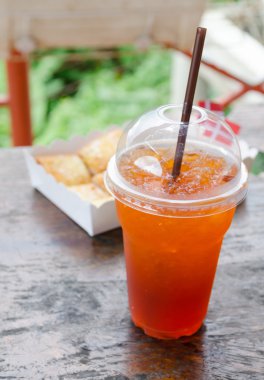 Plastik bardak ve ahşap masa tost limon çayı