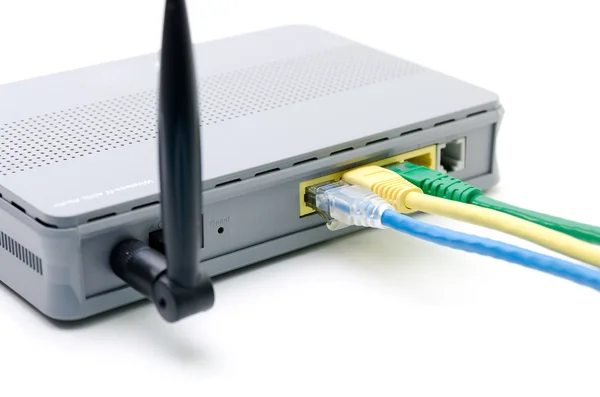 Zbliżenie sieci kable podłączone do routera wifi na biały — Zdjęcie stockowe