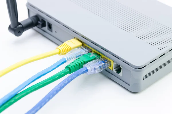 Primer plano de los cables de red conectados al router wifi en blanco — Foto de Stock