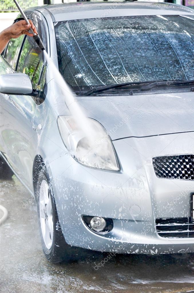 Car wash with flowing water and foam.