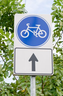 Mavi Bisiklet lane işareti ile ağaçlar ve gökyüzü arka plan