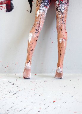 Arkasında güzel bacaklar ve ayaklar olan, sanatsal açıdan soyut boyalı seksi bir kadın, siyah, kırmızı ve beyaz boyalı bir balerin. Yaratıcı vücut resimleri, kopyalama alanı.