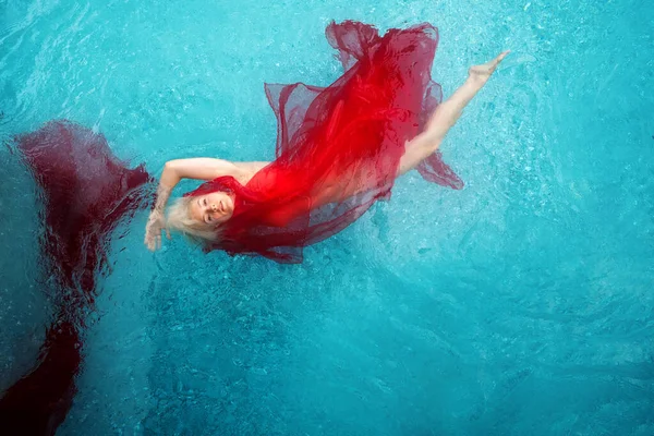 Bela Sexy Loira Jovem Nadando Com Panos Vermelhos Envolto Azul — Fotografia de Stock