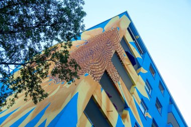 Sanatsal boyalı ev, gökdelen mavi ev duvarında büyük ayçiçeği çiçekleri, duvar resmi, kopyalama alanı.