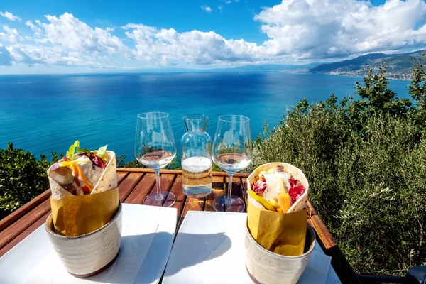 San Recco, Liguria, Camogli 'deki bir bardan somon kebabı ve Prosecco. Mavi deniz ve Ceneviz manzaralı.