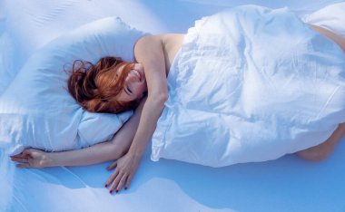 Yukarıdan bakıldığında, çekici, genç, seksi, şanslı, gülen kızıl saçlı, kızıl saçlı, beyaz, güneşli yatakta güneşin tadını çıkaran, uzay fotokopisi çeken....