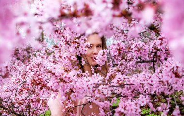 Şehvetli, baştan çıkarıcı, masum, pembe çiçekli pembe elbiseli genç bir kadının portresi Nisan ayında çiçek açıyor, bahar uyanıyor, sakura, kopyalama alanı