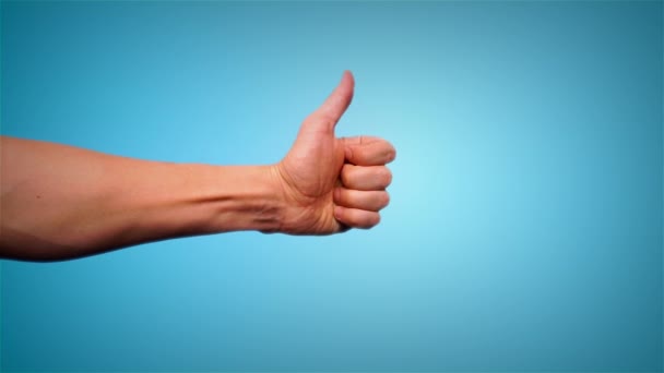Крупный план мужской руки, показывающий большие пальцы вверх, изолированные на синем фоне. Хорошая работа, подписание соглашения с успешной бизнес-концепцией. Мбаппе показывает пальцем вверх, рейтинг сервиса, концепция удовлетворенности — стоковое видео