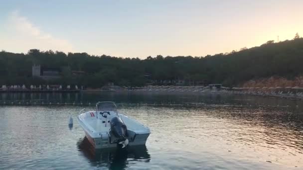 Een eenzame metalen vissersboot afgemeerd in de buurt van de kust op een lagune in de buurt van een prachtig resort strand — Stockvideo