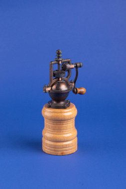 Kahve çekirdeği için öğütücü. Mavi arka planda eski bir değirmen