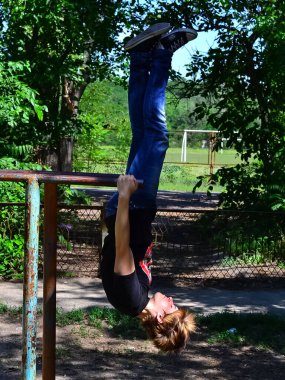 Rusya, Volgodonsk - 18 Haziran 2015: Bahçe jimnastiği. Dersler yatay çubuk ve paralel çubuklarda.