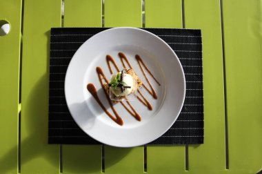 Çikolatalı meyve tatlı bir plaka üzerinde. Bir restoranda tablo ayarı.