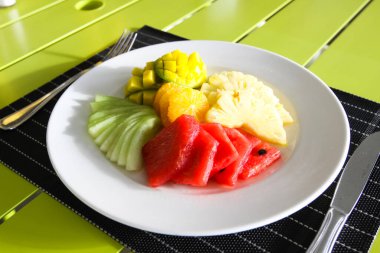 Restoran menü. Ananas, karpuz ve portakal salatası, karışık meyve. Bir restoranda tablo ayarı.