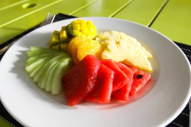 Restoran menü. Ananas, karpuz ve portakal salatası, karışık meyve. Bir restoranda tablo ayarı.